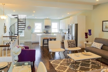 A living room filled with furniture and a kitchen.