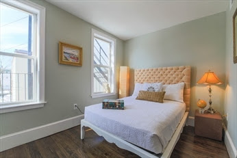 A bed room with a neatly made bed and a window
