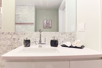 A bathroom with marble counter tops and white sink.