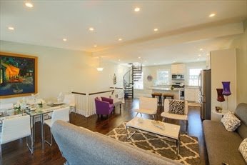 A living room with white walls and wooden floors