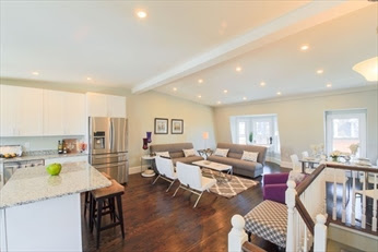 A living room with a kitchen and dining area