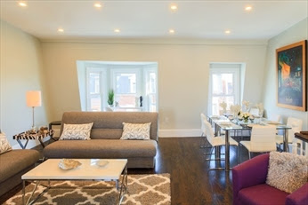 A living room with a couch, chair and table.