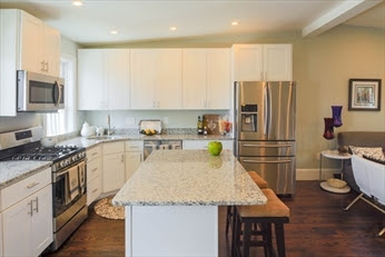 A kitchen with white cabinets and stainless steel appliances.