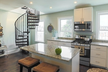 A kitchen with stairs and a stove in it