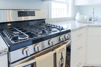 A stove with a towel hanging on it.